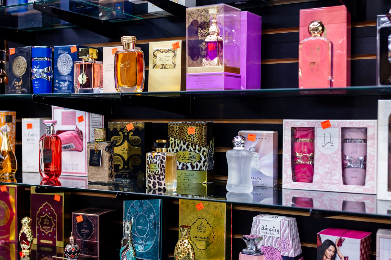 Perfume and fragrance bottles on glass display shelves